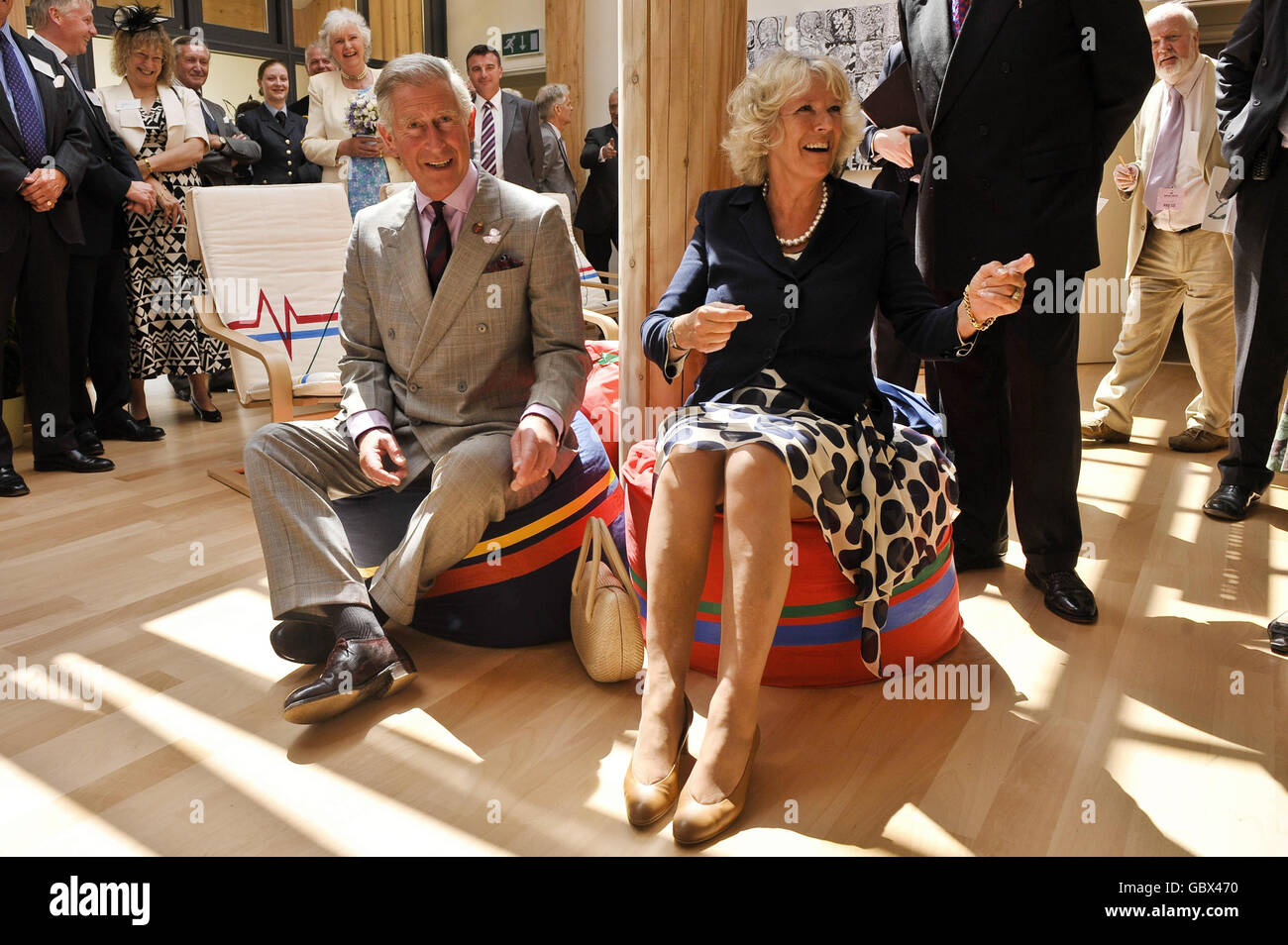 The Prince of Wales and the Duchess of Cornwall sit on bean bags at the Integrated Health Centre before listening to a presentation from pupils during their visit to Penair School, Truro, Cornwall. Stock Photo