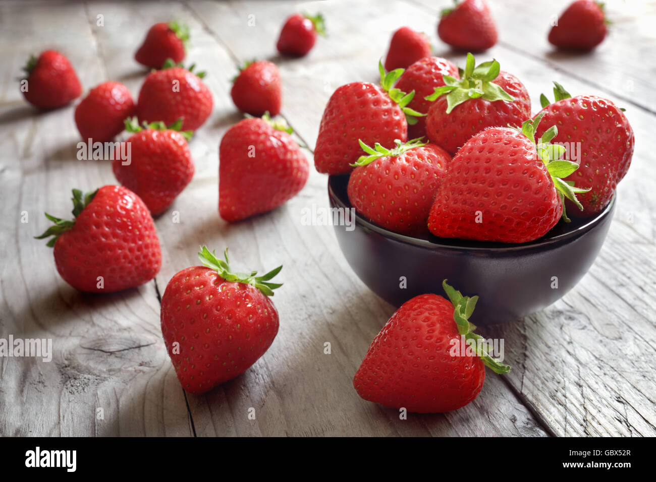 Strawberries fresh picked in a bowl on wood table antioxidant organic superfood concept for healthy eating and nutrition Stock Photo