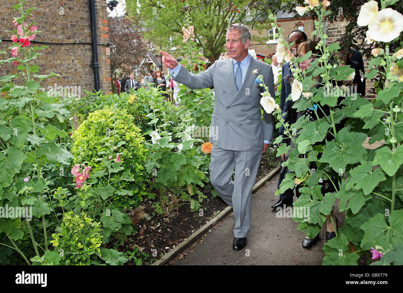 The Prince of Wales, centre, patron of the Almshouse Association, walks through an allotment during a visit to St Pancras almshouses in north London to celebrate the 150th anniversary of the Almshouses. Stock Photo