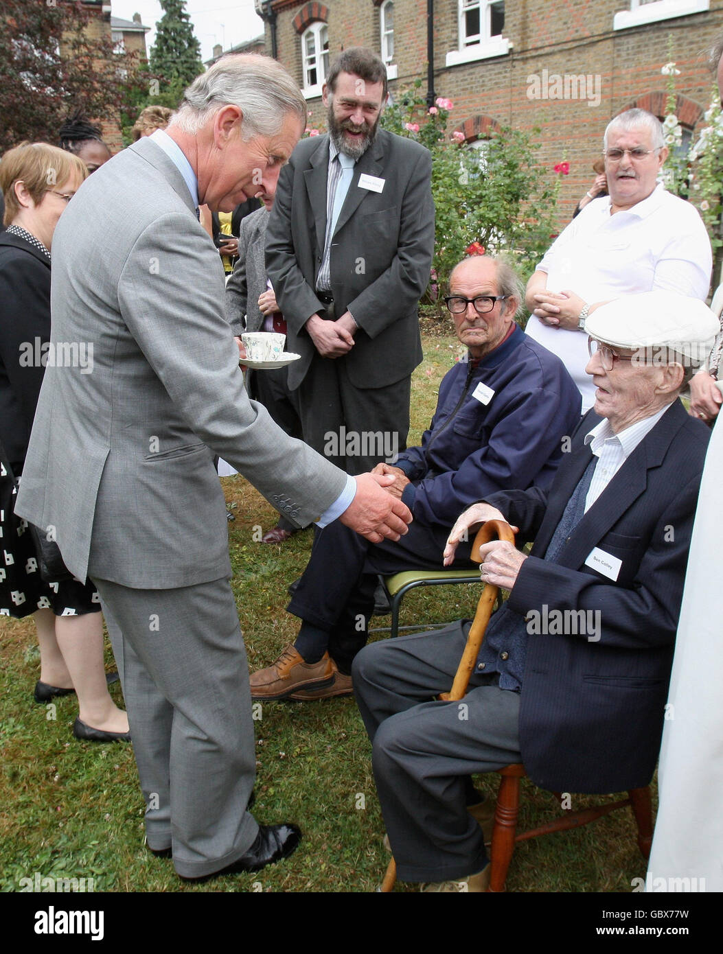 The Prince of Wales, centre, patron of the Almshouse Association, talks with residents, Harold Clarke, left and Ben Colley, right, during a visit to St Pancras almshouses in north London to celebrate the 150th anniversary of the Almshouses. Stock Photo