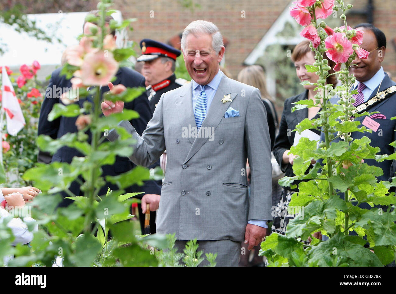 The Prince of Wales, centre, patron of the Almshouse Association, walks through an allotment during a visit to St Pancras almshouses in north London to celebrate the 150th anniversary of the Almshouses. Stock Photo