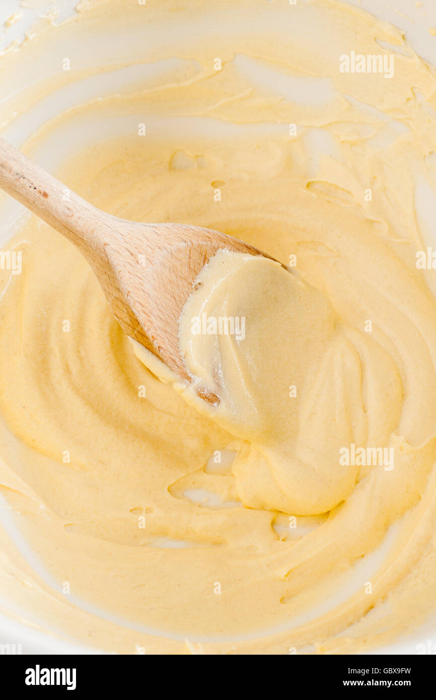 Mixing or blending cake batter in a bowl selective focus on the spoon Stock Photo