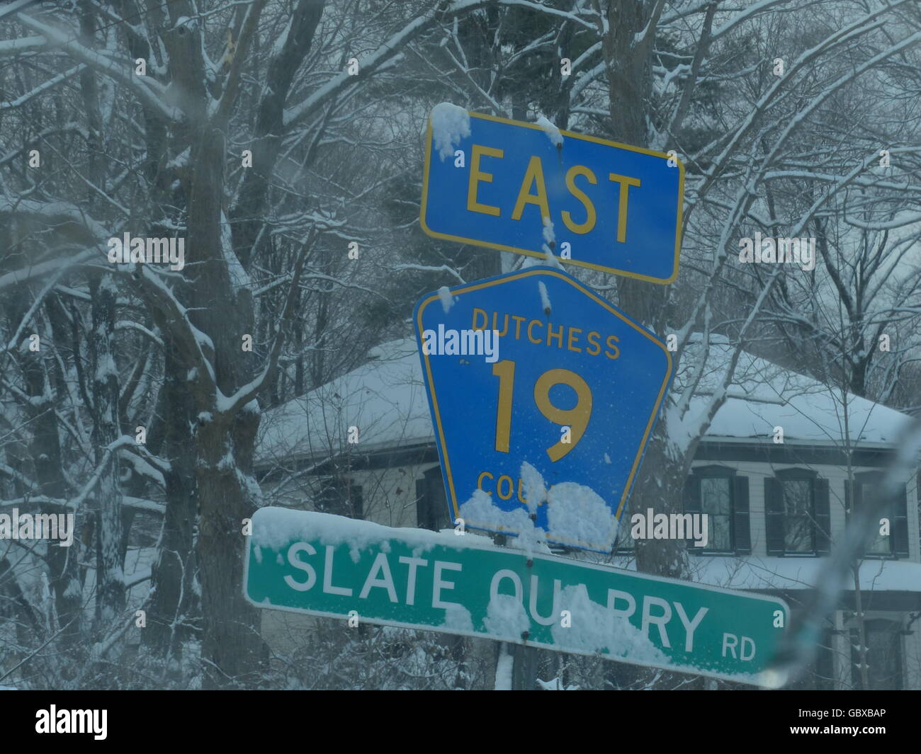 winter driving, slippery roadway, low visibility, snow, sleet, splash, caution, accident, snow covered sign Stock Photo