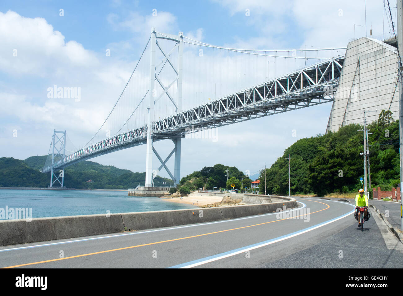 A cyclist cycling under the Innoshima Bridge connecting the islands of Innoshima and Mukaishima in the Seto Inland Sea.. Stock Photo