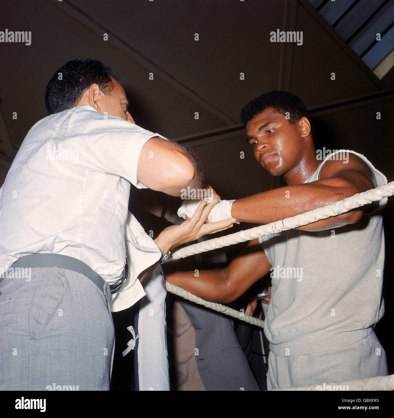 World heavyweight champion Muhammad Ali (r) has his hands taped by his trainer Angelo Dundee (l) during a training session in the White City drill hall Stock Photo
