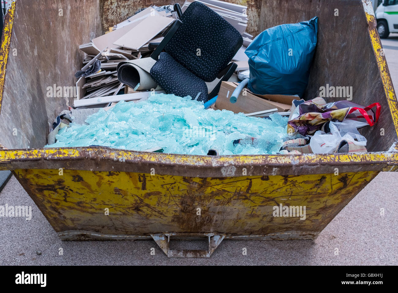 Disposal of waste in a rusty container Stock Photo - Alamy