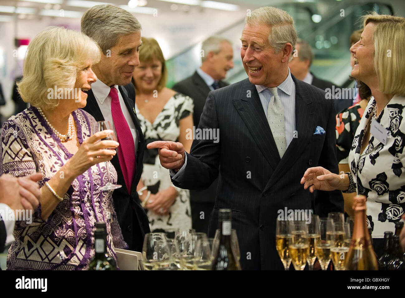 The Prince of Wales points towards the Duchess of Cornwall as she holds a glass of alcohol during a visit to a branch of Marks and Spencer in the Westfield shopping centre, London, to help celebrate the popular retailer's 125th anniversary. Stock Photo