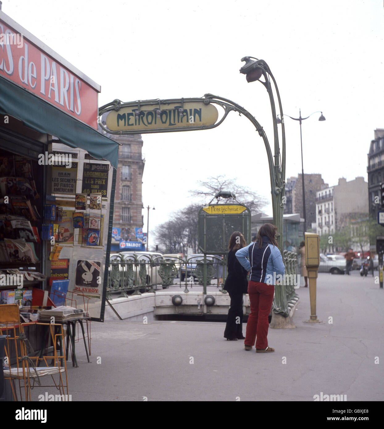1970s, picture shows an entrance to a Paris metro station with it's distinctive signage and a newspaper stand, Paris, France. Stock Photo