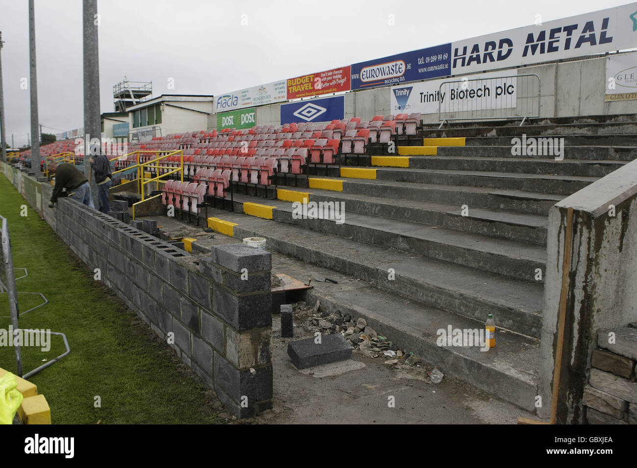 Builders repair a wall that collapsed on supporters last night during a football match between Bray Wanderers and Shamrock Rovers at Carlisle Grounds in Bray, Ireland. Stock Photo