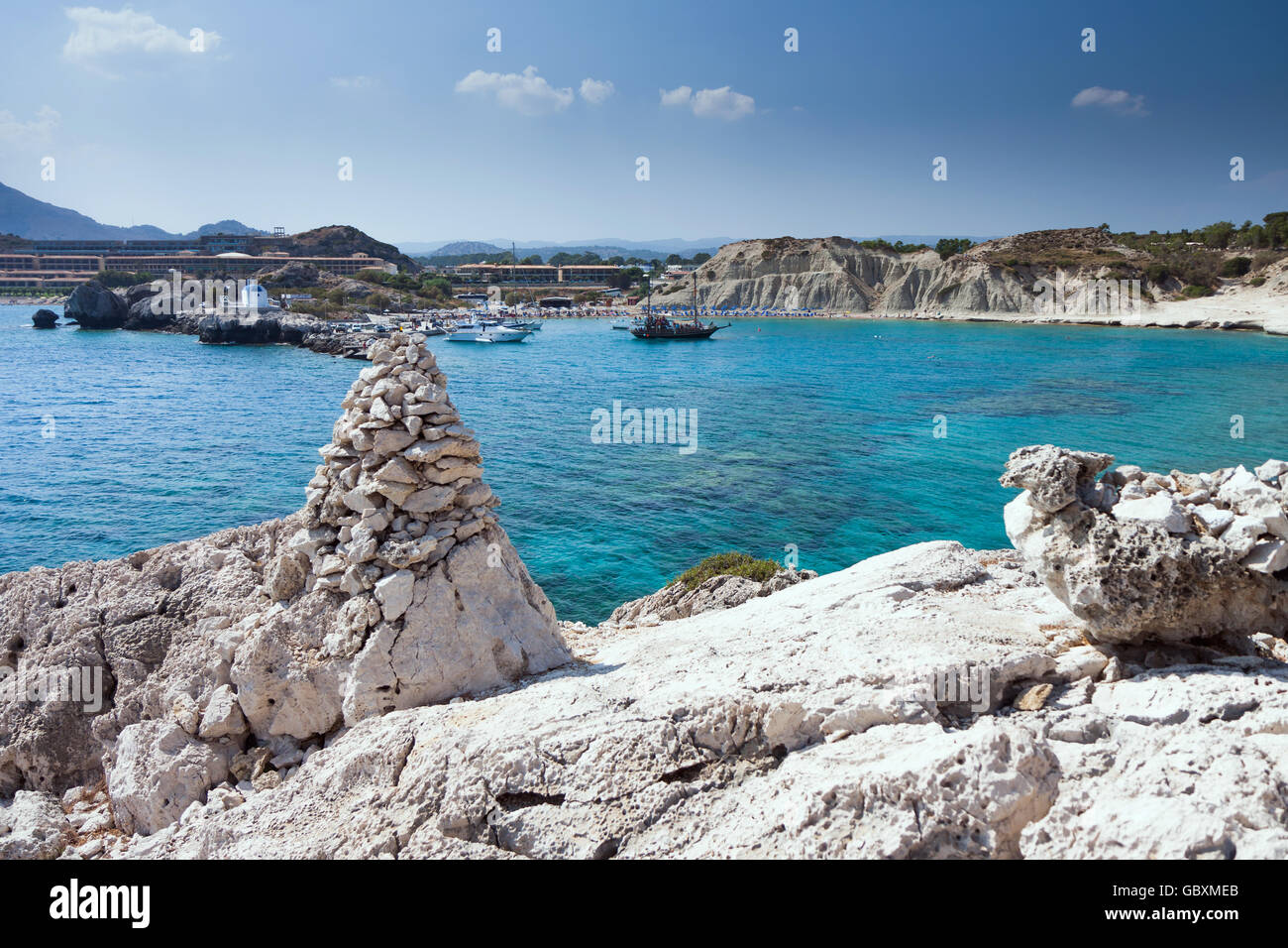 Kolymbia beach with the rocky coast in Greece. Cruise ship coming in the port. Stock Photo