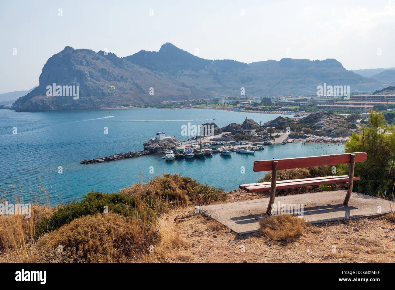 Kolymbia beach with the rocky coast in Greece. Empty bench on the island of Rhodes. View of the coast in Kolympia Stock Photo