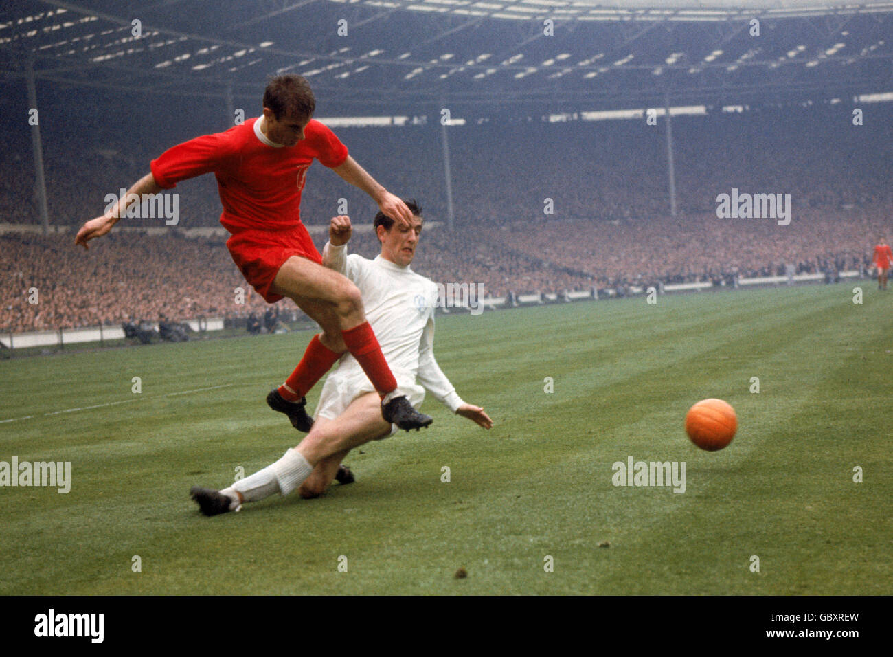 Leeds United's Norman Hunter (r) slides in too late to prevent Liverpool's Roger Hunt (l) firing the ball across Stock Photo