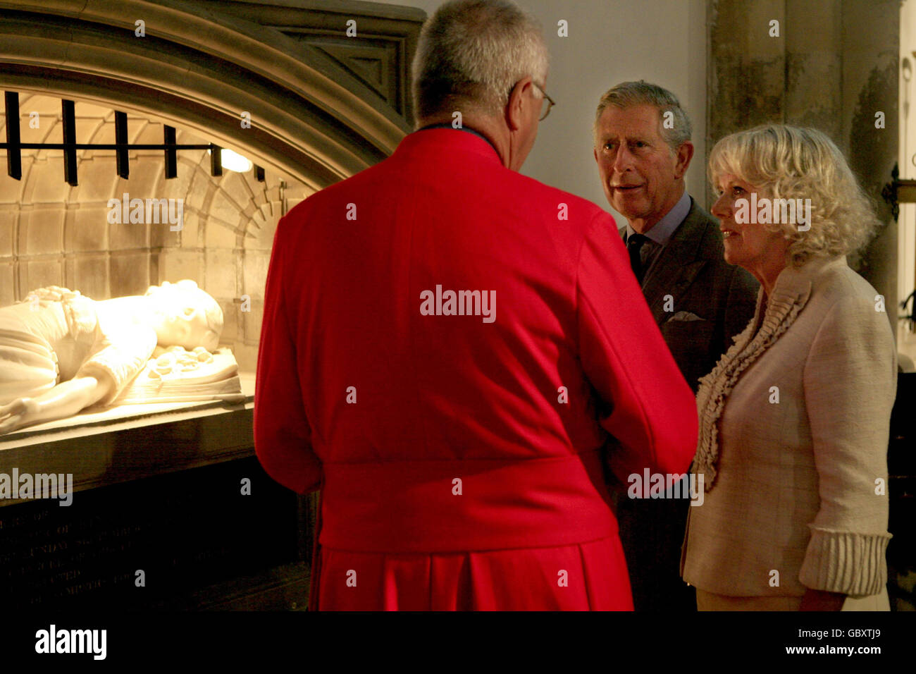 The Prince of Wales and the Duchess of Cornwall are shown the tomb of Princess Elizabeth (daughter of Charles I) by the Vicar of Newport Minster, Canon Dr Stephen Palmer, as they view some of the renovation work there, during a visit to the Isle of Wight Farmers' Market in St Thomas Square, Newport, on the Isle of Wight. Stock Photo