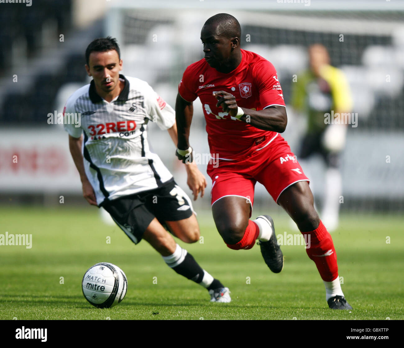 FC Twente Cheick Tiote gets away from Swansea's Leon Britton during the Pre-season Friendly match at The Liberty Stadium, Swansea. Stock Photo