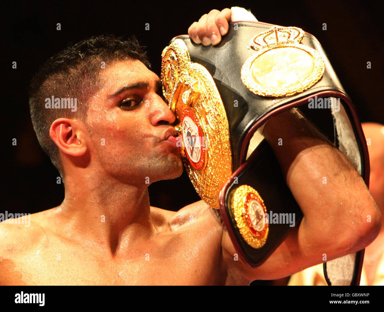 Amir Khan kisses his belt as he celebrates victory over Andreas