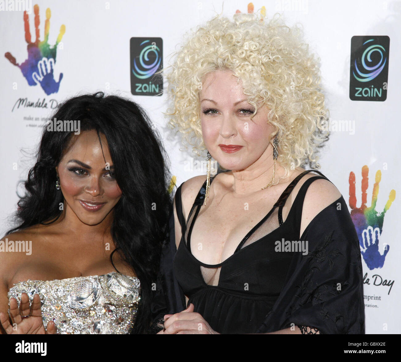 Singers Lil' Kim and Cyndi Lauper, right, attend the Mandela Day: A 46664 Celebration Concert at Radio City Music Hall in New York City. Stock Photo