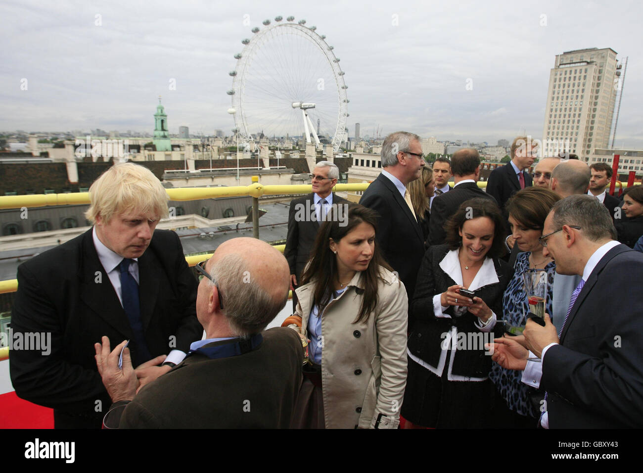 The Mayor of London Boris Johnson (left) is interviewed by the media as he attends a topping out ceremony on the 13th floor of the Park Plaza Westminster Bridge Hotel on the south-side of Westminster Bridge in London. Stock Photo