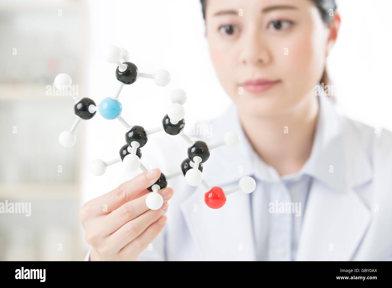 asian female scientist holding and looking at molecular model doing the Science research for human longevity Antidote Stock Photo