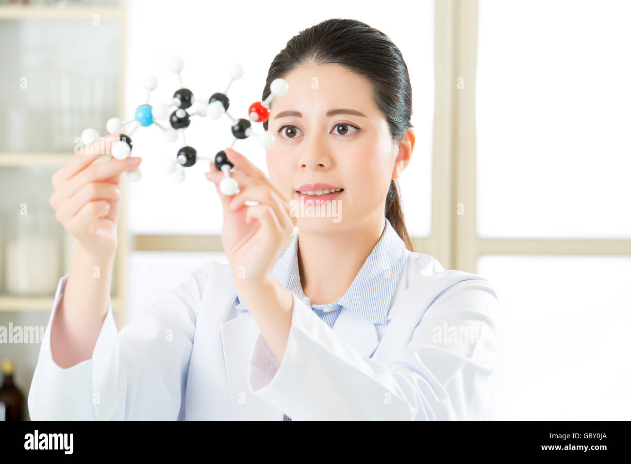 asian female scientist Examining the building blocks of life with molecular model in laboratory