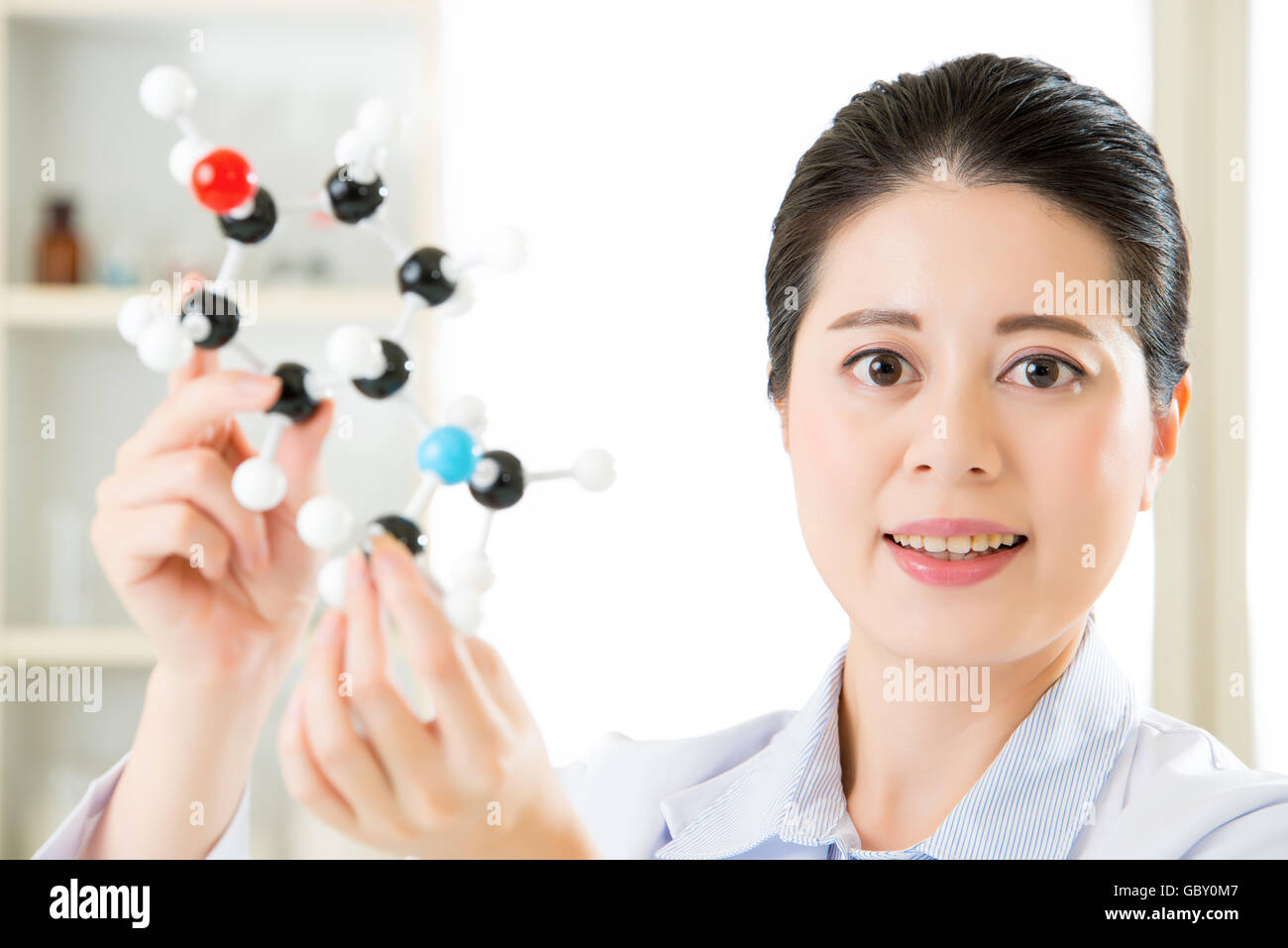 asian female scientist Examining the building blocks of life with molecular model in laboratory