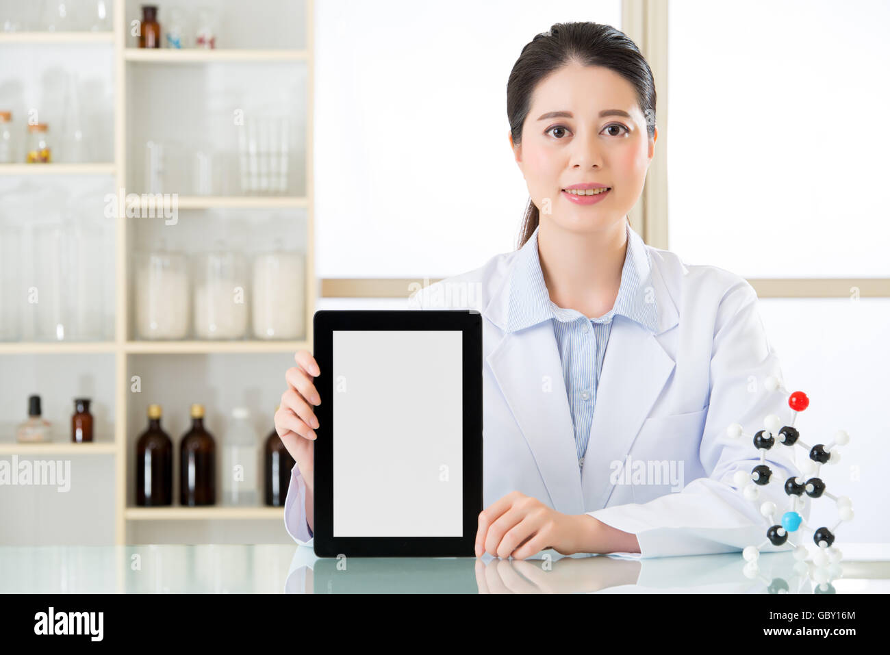 asian female chemist use notepad to research for future Chemical formula and holding molecular model Stock Photo