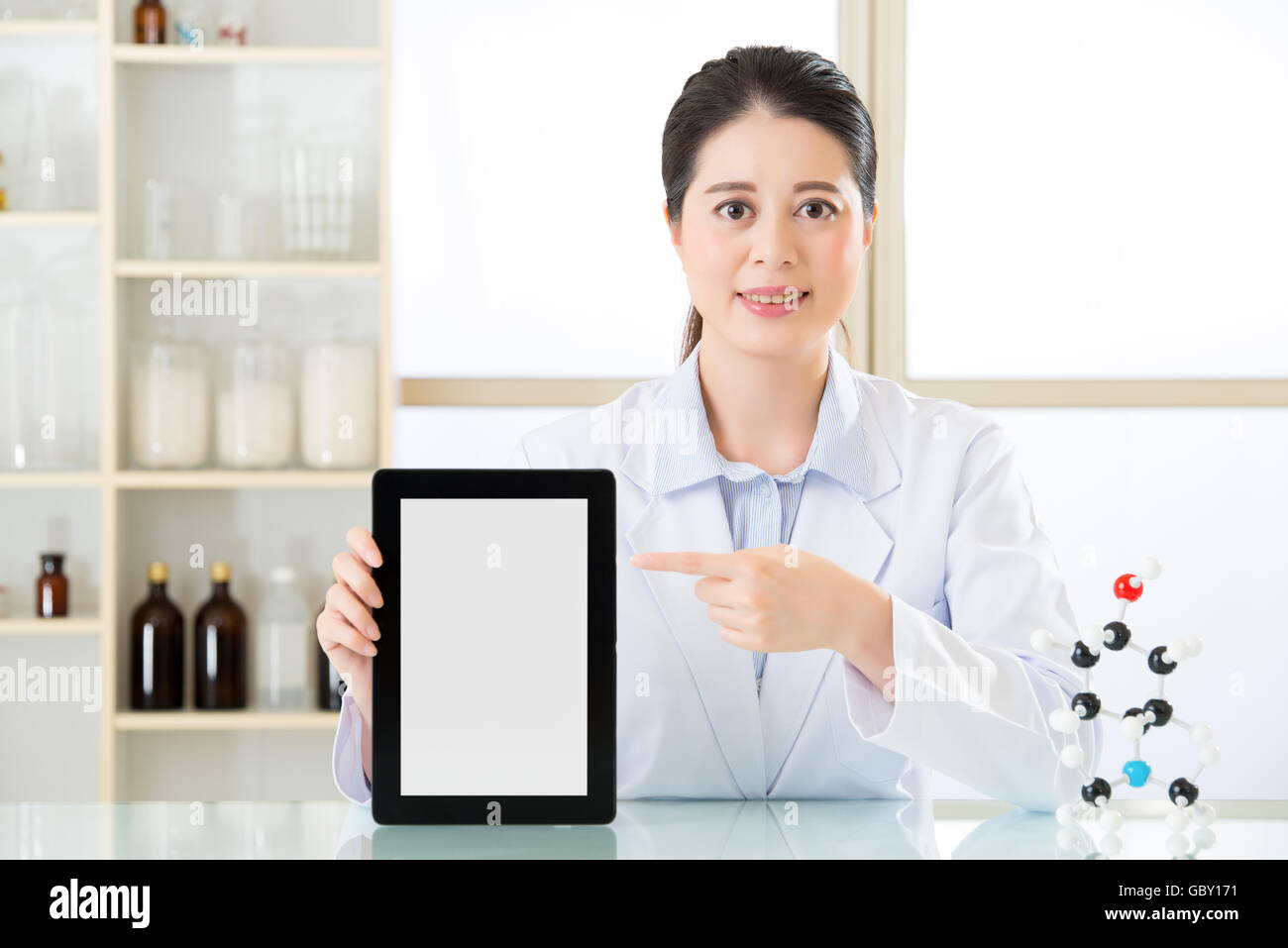 asian female chemist use notepad to research for future Chemical formula and holding molecular model Stock Photo