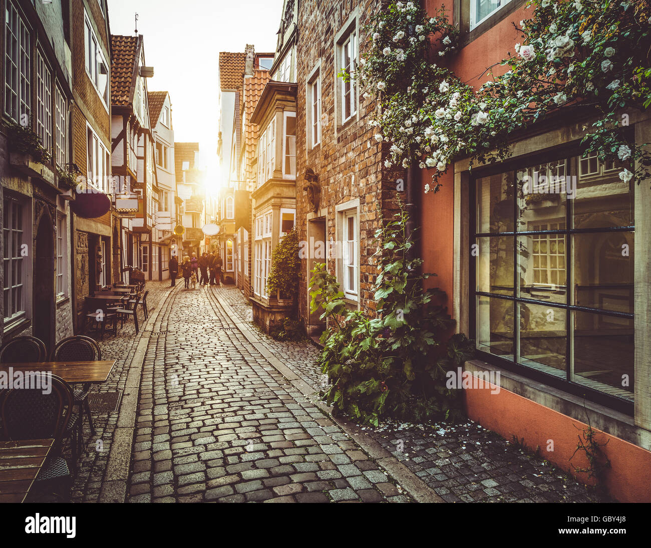 Enchanting street scene in an old town in Europe at sunset with retro vintage filter effect Stock Photo