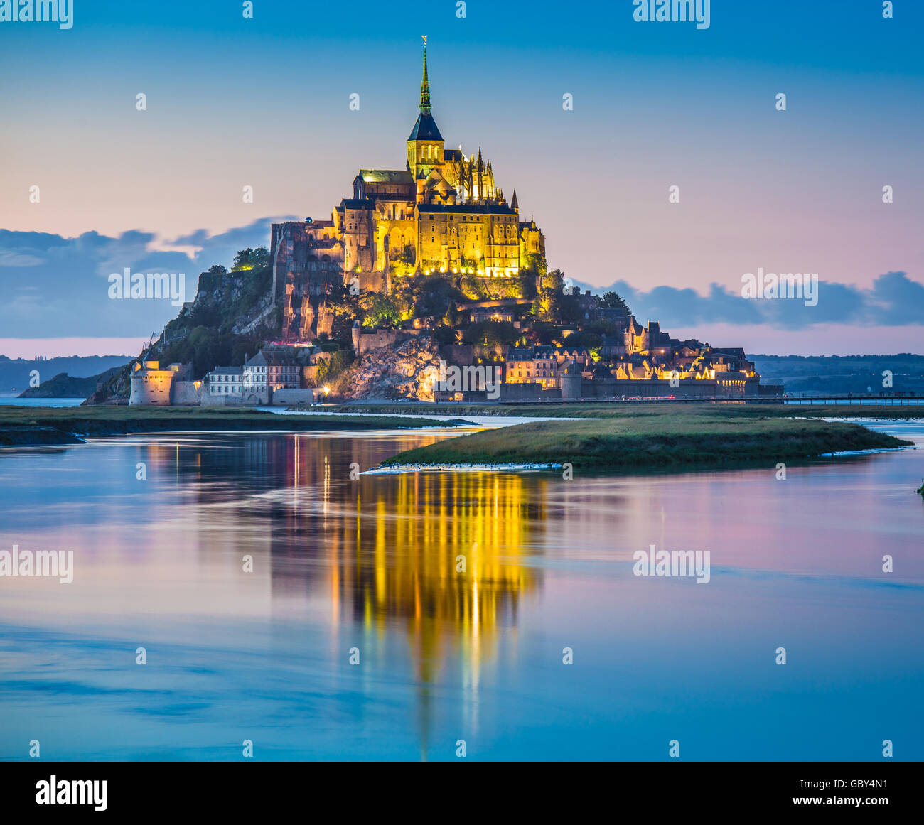 Classic view of famous Le Mont Saint-Michel tidal island in beautiful twilight during blue hour at dusk, Normandy, France Stock Photo
