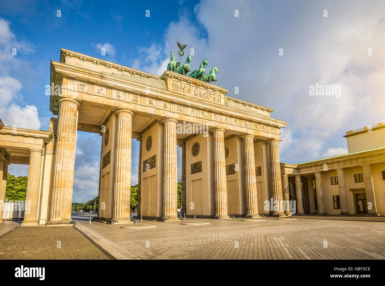Classic view of famous Brandenburg Gate in beautiful golden morning light with blue sky and clouds, central Berlin, Germany Stock Photo