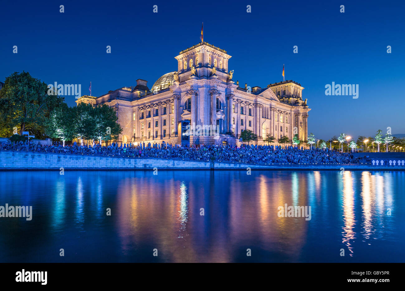 Classic view of famous Reichstag building reflecting in Spree river in twilight during blue hour at dusk, Berlin, Germany Stock Photo