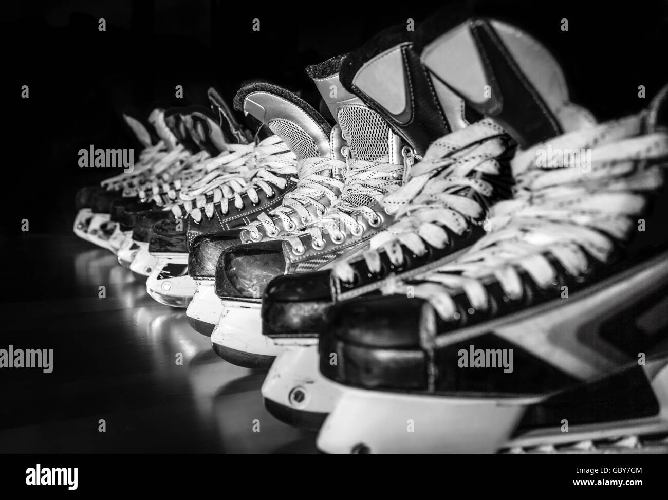 Pairs of hockey skates lined up in a locker room Stock Photo