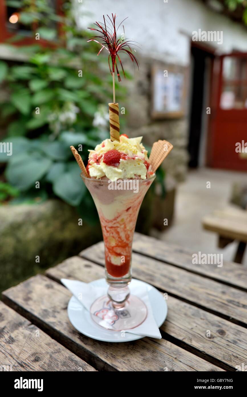 A Strawberry ice cream sundae courtesy of Roskilly's  Tregellast Barton Farm, St Keverne, Helston TR12 6NX Cornwall England UK Stock Photo