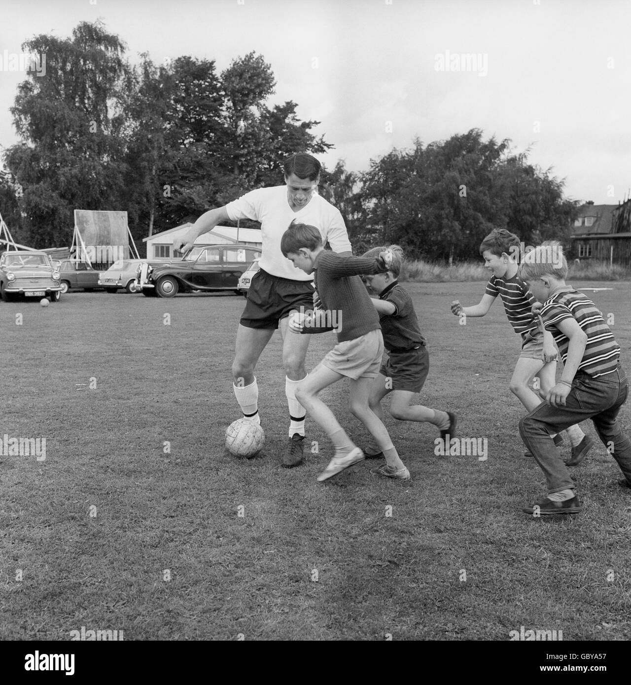 Fulham player Bobby Robson gets some unofficial help during training at Ewell, Surrey, from his sons, Paul, 7, and Andrew, 9, and their friends, Terry, 8, and Roger Allen, 7. Stock Photo