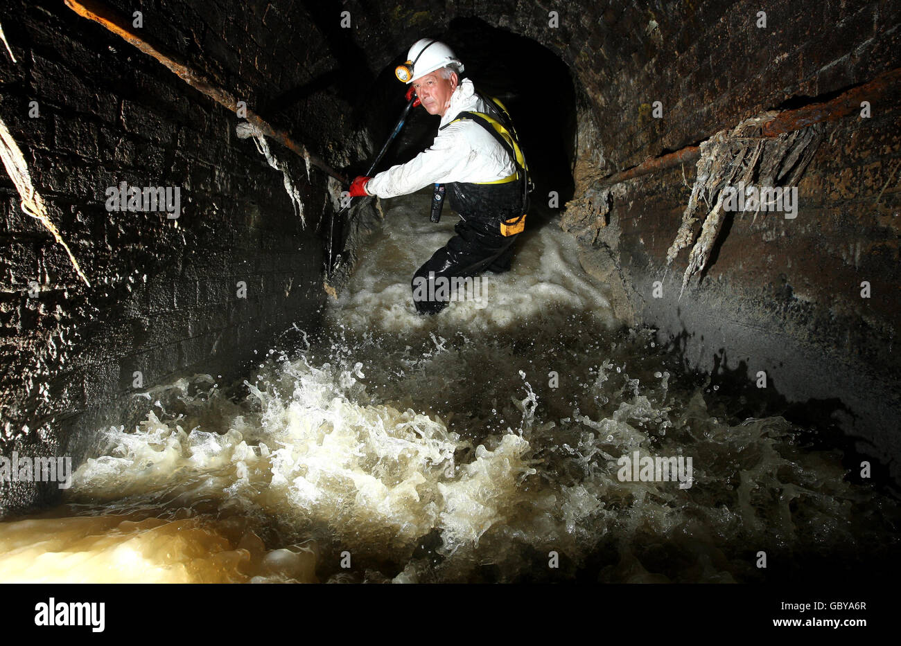 Thames Water Catchment Engineer Rob Smith works to clear a blockage of fat and sanitary products from London's sewer network as the company has launched a campaign to stop sewer abuse. Stock Photo