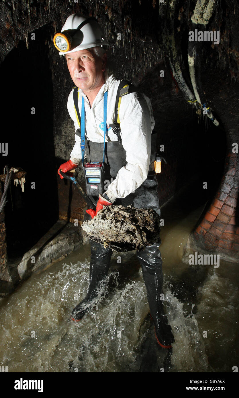 Thames Water Catchment Engineer Rob Smith works to clear a blockage of fat and sanitary products from part of London's sewer network as the company has launched a campaign to stop sewer abuse. Stock Photo