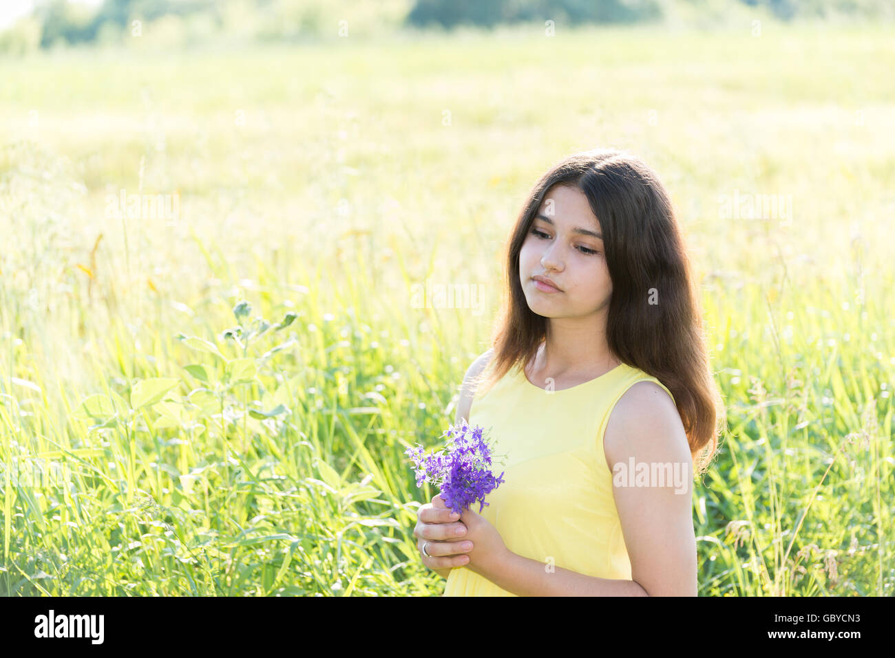 Girl with bouquet of wildflowers in summer field Stock Photo - Alamy