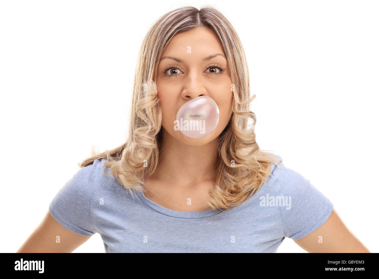 Studio shot of a woman blowing up a bubble from a chewing gum isolated on white background Stock Photo