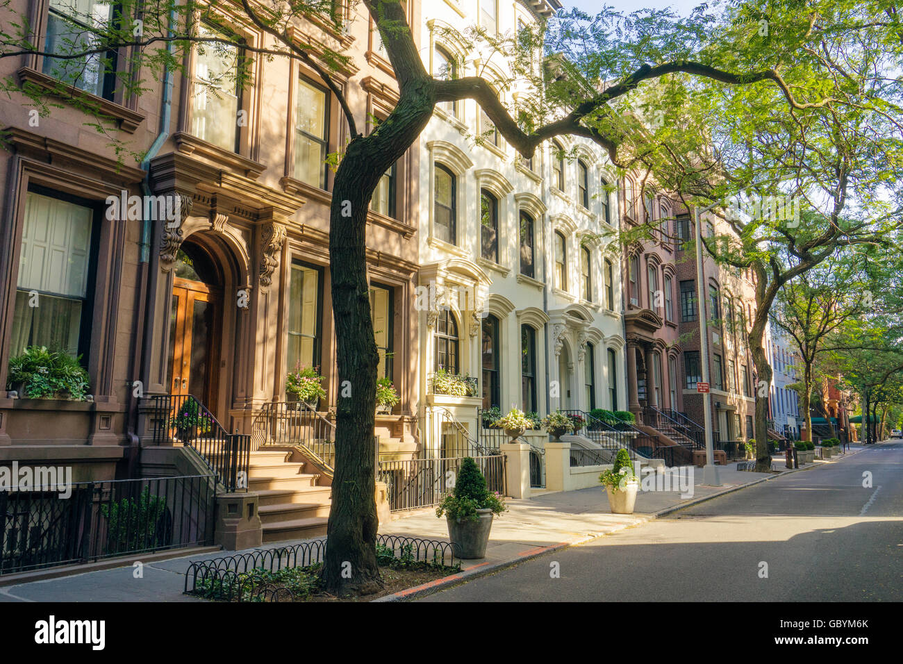 Attractive brownstone buildings along a sun-dappled residential street in Brooklyn Heights, New York Stock Photo