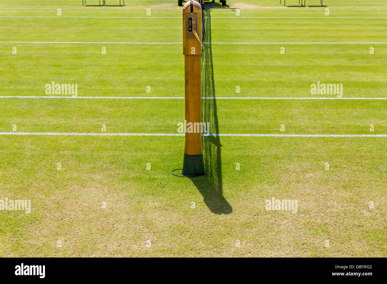 Grass tennis court and wooden net pole Stock Photo