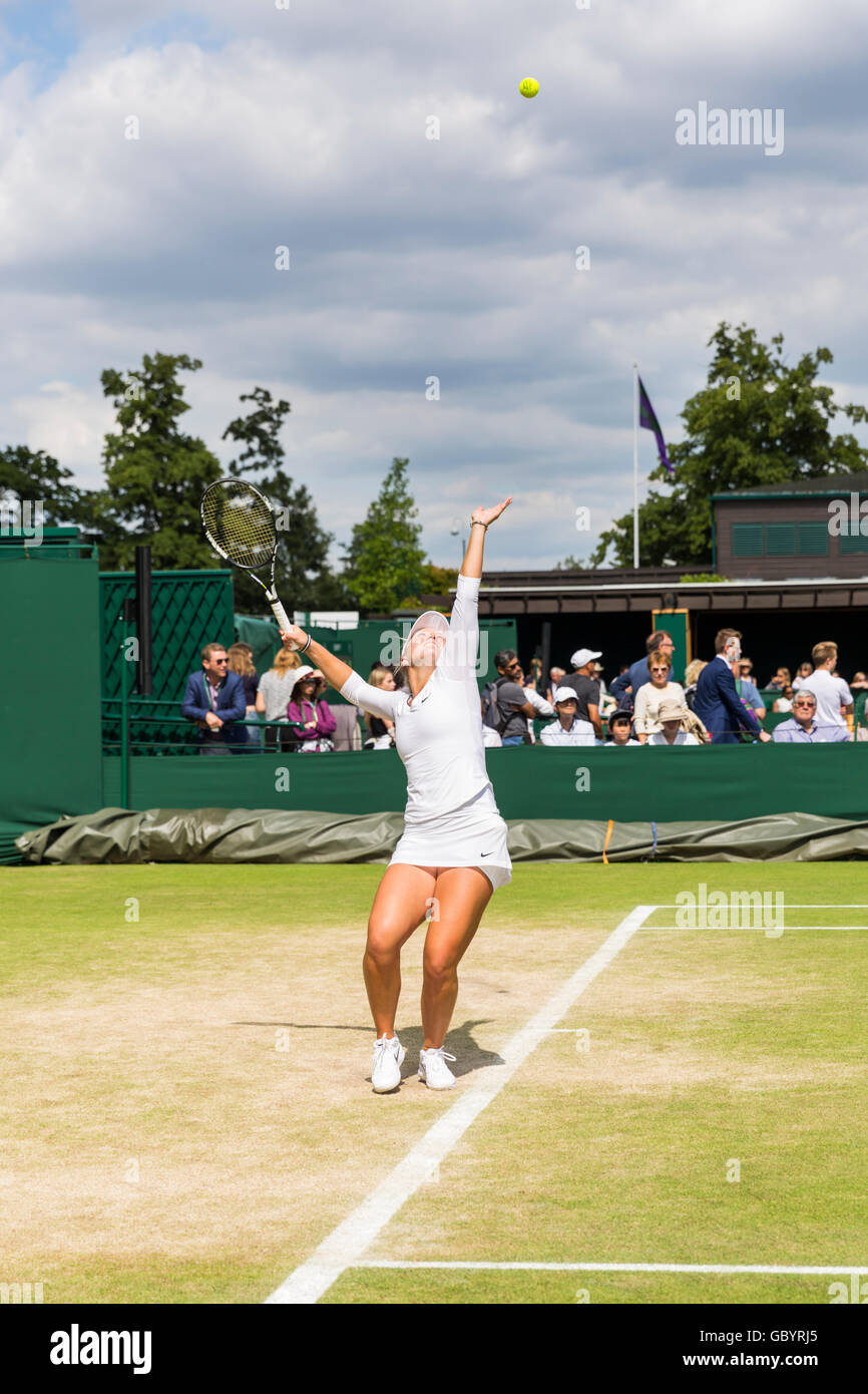 Female tennis player serving on an outside court during the Wimbledon 2016 Championships, London Stock Photo