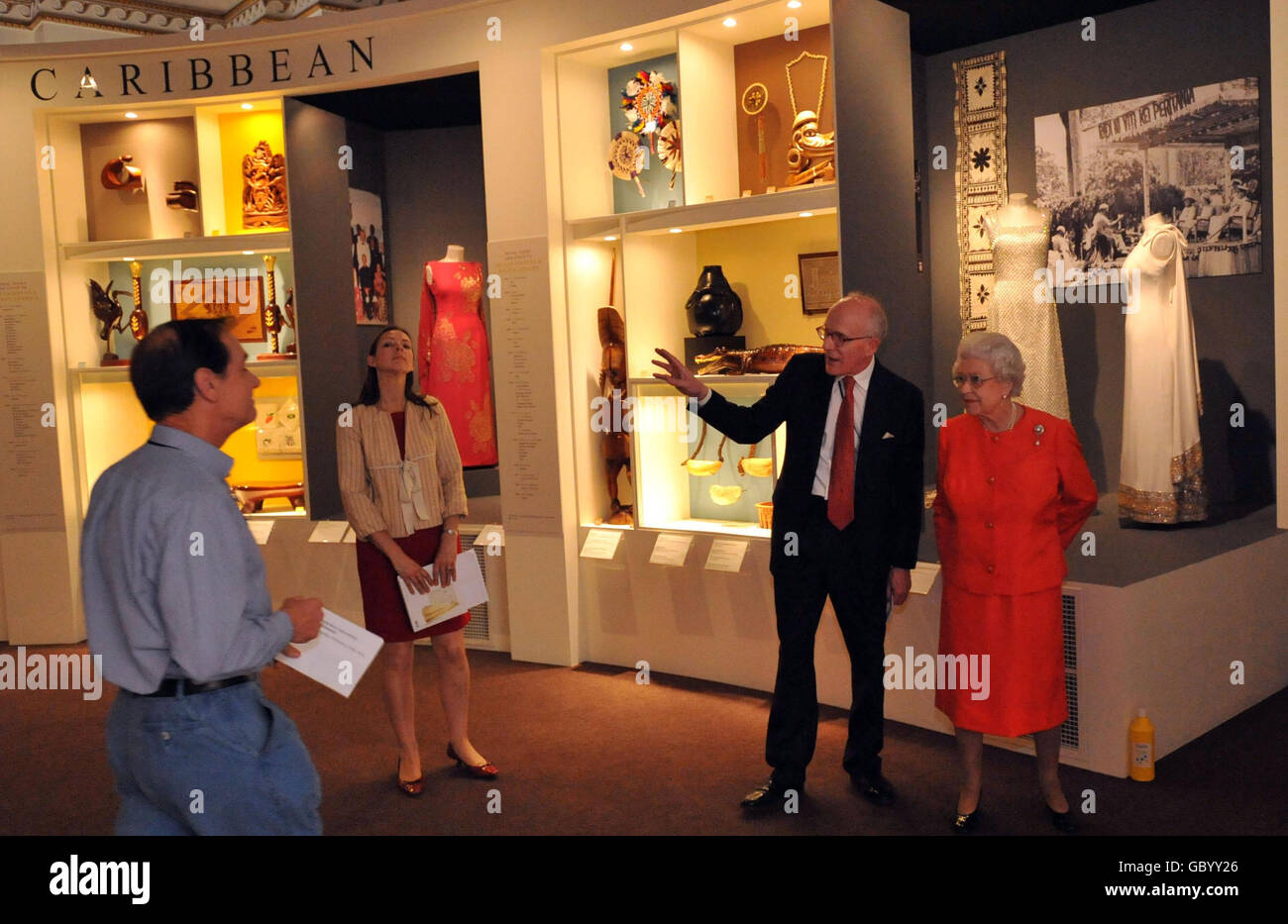 Britain's Queen Elizabeth II is shown around the Commonwealth exhibition at Buckingham Palace by Sir Hugh Roberts, Director of the Royal Collection (right), and Assistant Curator Caroline De Guitaut. Stock Photo