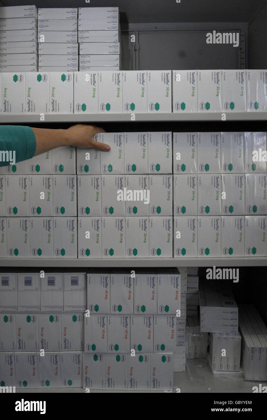 A member of staff at Mile End Hospital's anti-viral collection point, picks up packets of Tamiflu from a store cupboard. Picture date: Friday July 24, 2009. See PA story HEALTH Flu. Photo credit should read: Clive Gee/PA Wire Stock Photo