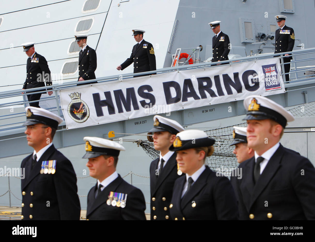 The ship's company line up on the quayside for the commissioning ceremony of the Royal Navy's newest warship, HMS Daring at the Royal Navy dockyard in Portsmouth. Stock Photo