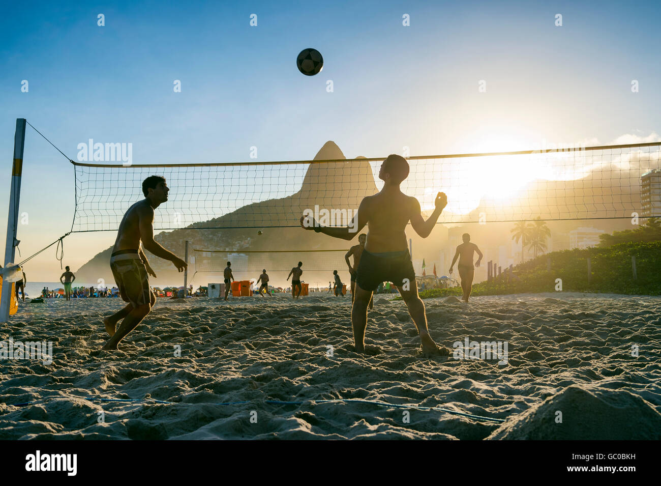 RIO DE JANEIRO - MARCH 27, 2016: Brazilians play beach futevôlei (footvolley), a sport combining football/soccer and volleyball. Stock Photo