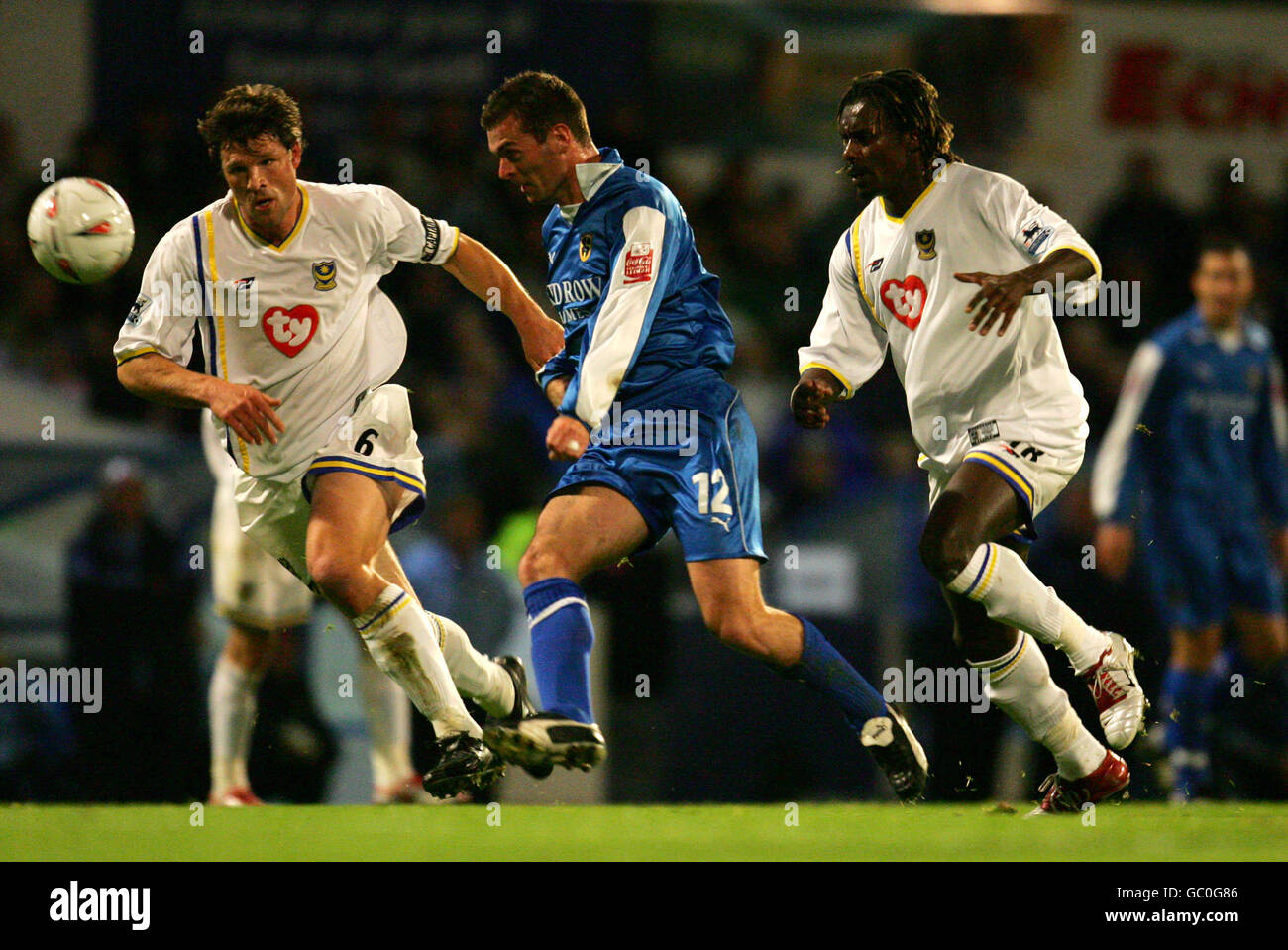 Cardiff City's Willie Boland (c) battles for the ball with Portsmouth's Arjan De Zeeuw (l) and Aliou Cisse (r) Stock Photo