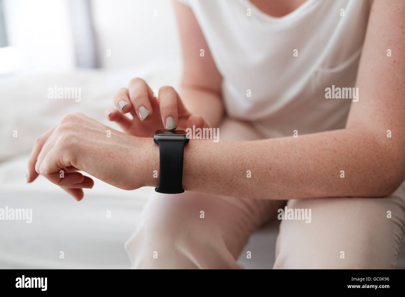 Close up image of a woman using smartwatch to check time. Hands of a female with smart watch. Stock Photo