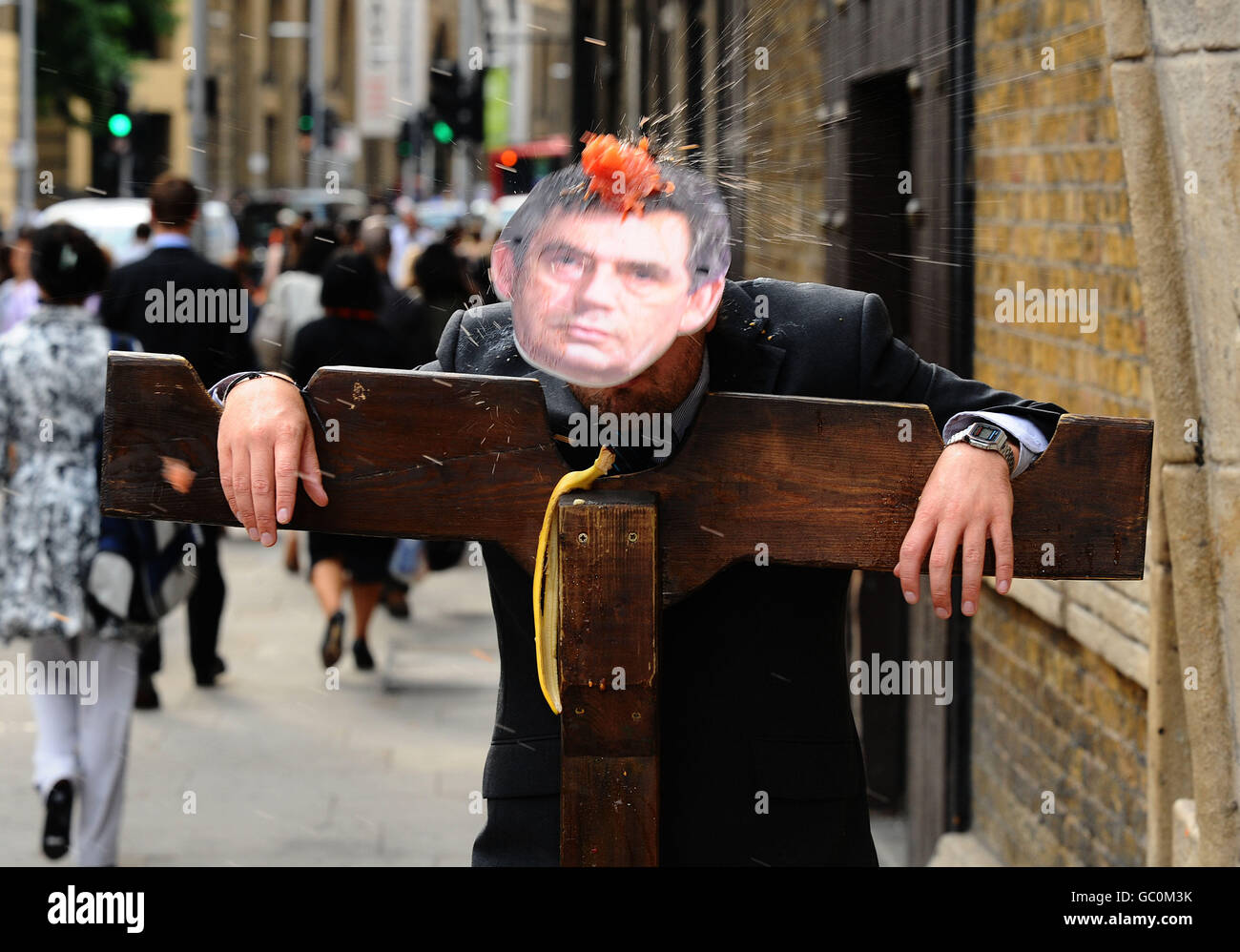 'Gordon Brown' is put in the stocks and members of the public invited to pelt him with fruit and veg as he loses the vote in in the London Dungeons 'Hang, Stocks or Torture' poll. Stock Photo