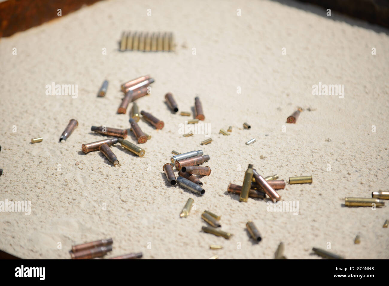 Bullets and spent cases on sand from hand gun Stock Photo