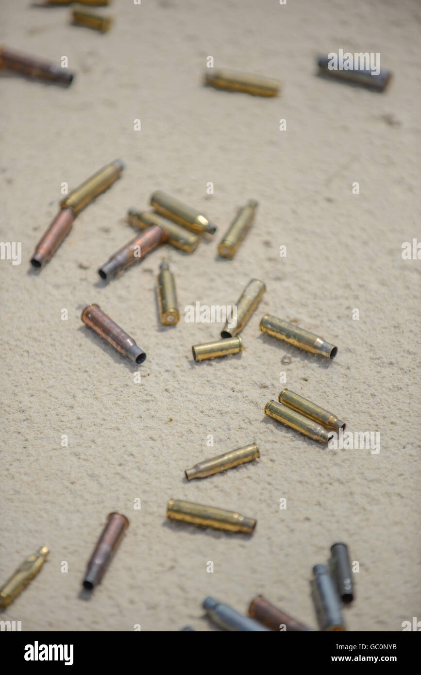 Bullets and spent cases on sand from hand gun Stock Photo