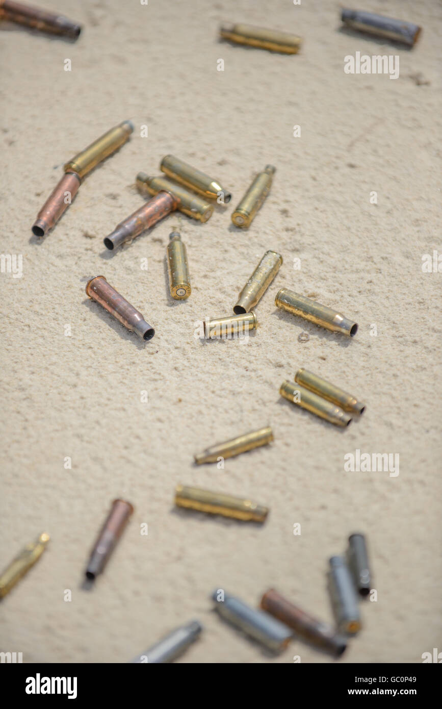 Bullets and spent cases on sand from hand gun Stock Photo